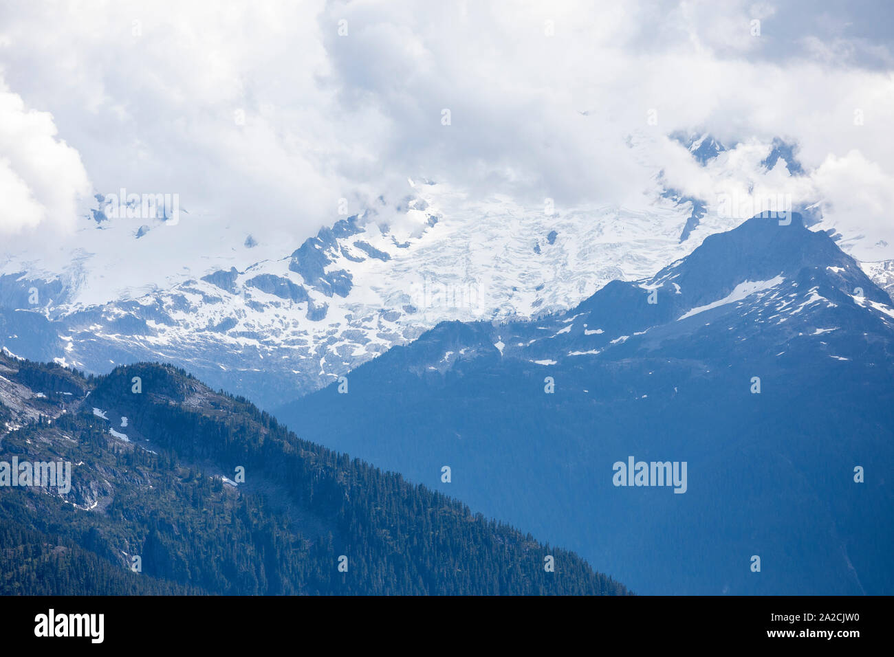 A mountain peak with a massive glacier is shrouded in clouds Stock ...