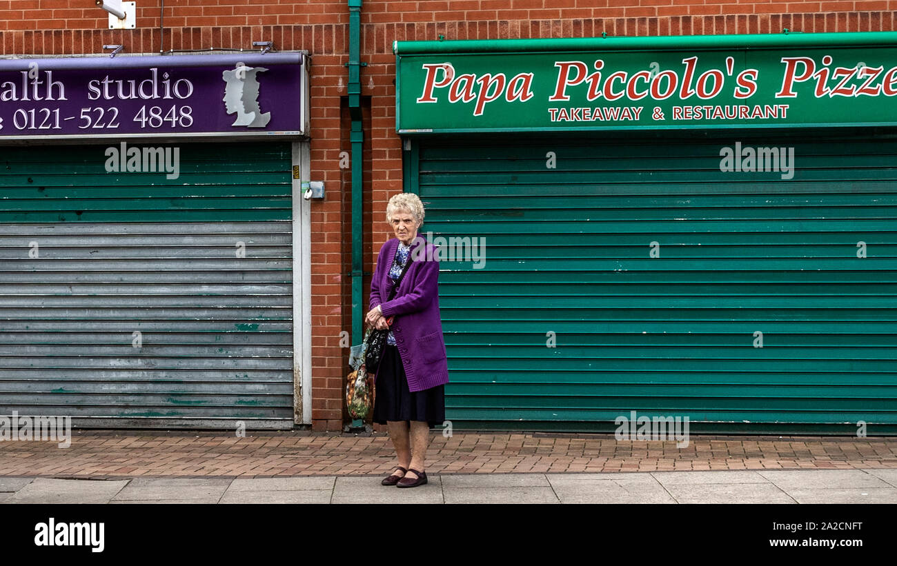 Elderly women standing in front of closed down shops, Tipton in the borough of Sandwell, West Midlands. Stock Photo