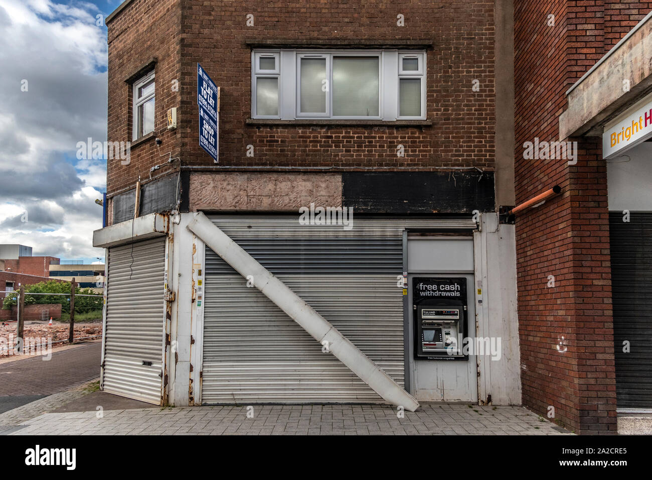 Boarded up business, advertising shop and flat to let and a free cash machine. West Bromwich, West Midlands, Black Country, UK, 2019 Stock Photo