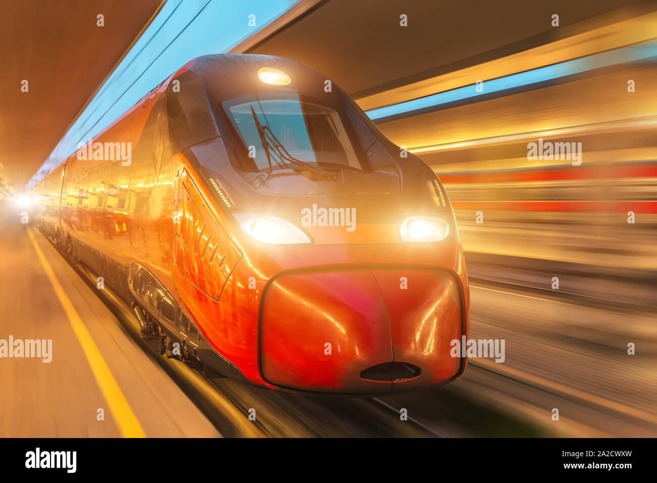 Night passenger high-speed train passing the station in the city Stock Photo