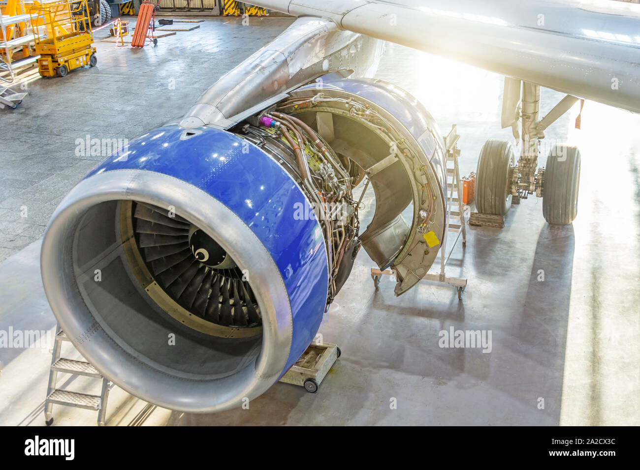 Airplane in the hangar for maintenance, view of the engine wing with the hood open Stock Photo