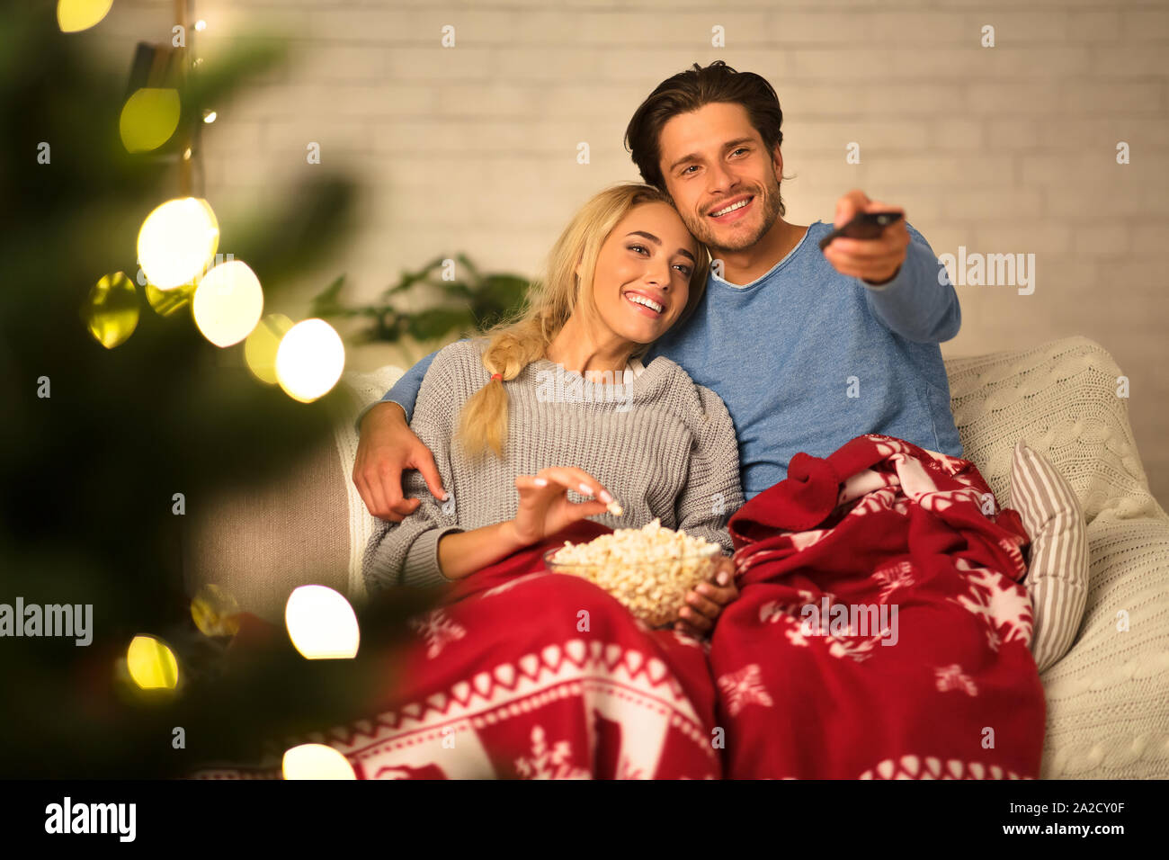 Loving couple watching tv at Christmas eve Stock Photo