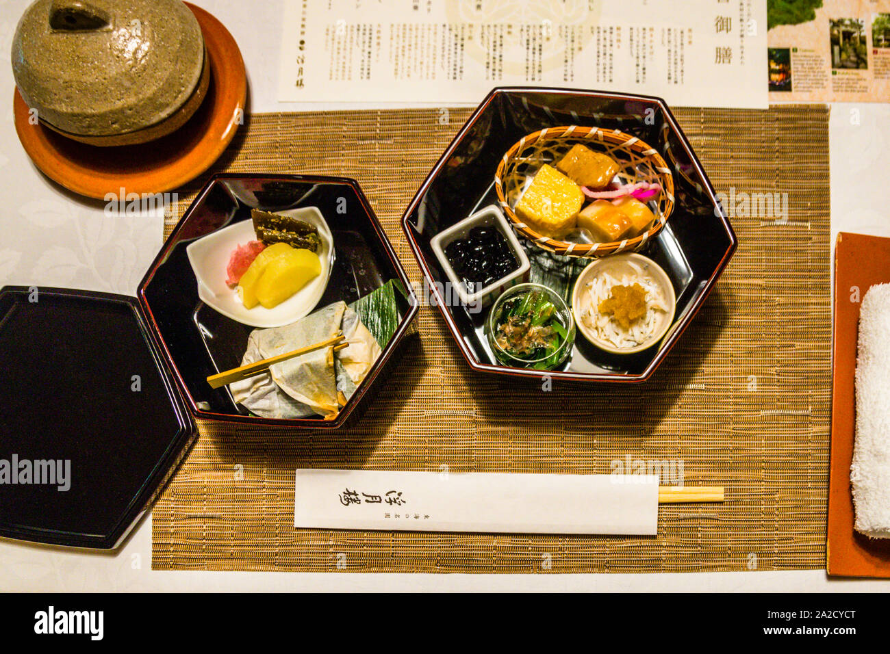 Traditional lacquer dishes with grilled fish, black beans, and other side dishes are arranged at the Fugetsuro restaurant in Shizuoka, Japan – the building was once home to the last shogun, Tokugawa Yoshinobu, and still serves his favourite dishes today. Stock Photo