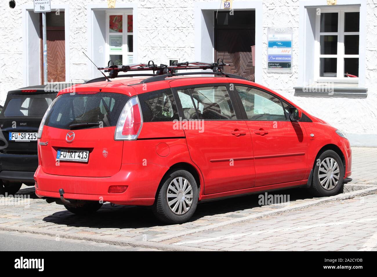 FURTH, GERMANY - MAY 6, 2018: Red Mazda 5 compact MPV family car parked in Germany. There were 45.8 million cars registered in Germany (as of 2017). Stock Photo