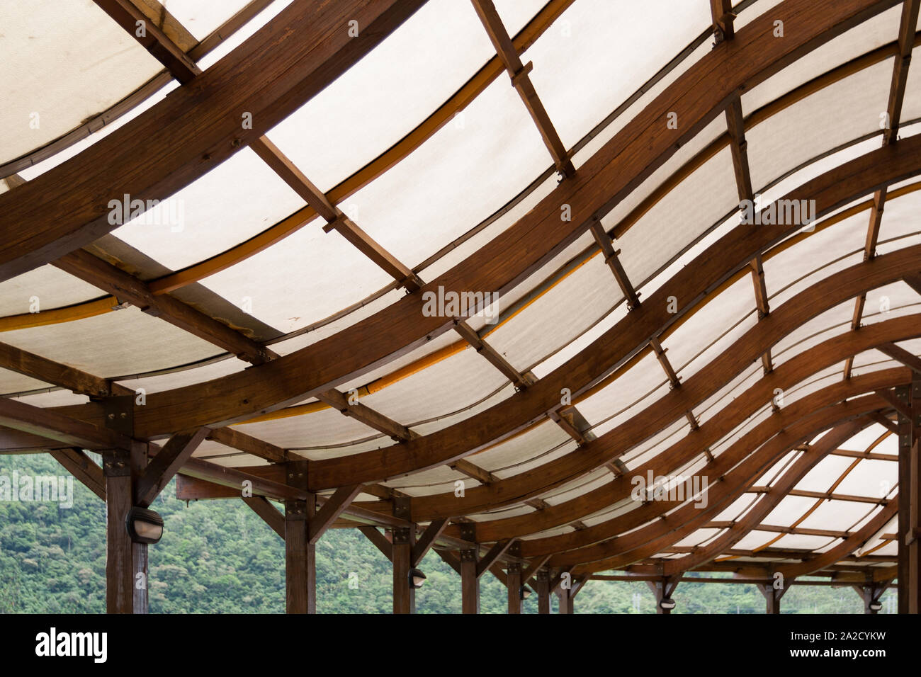 Wood beams roof structure with S curve shape, covered with polycarbonate  sheet Stock Photo - Alamy