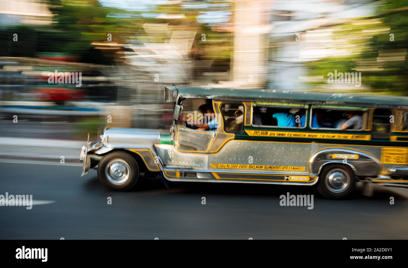 Jeepney moving on road, Manila, Philippines Stock Photo