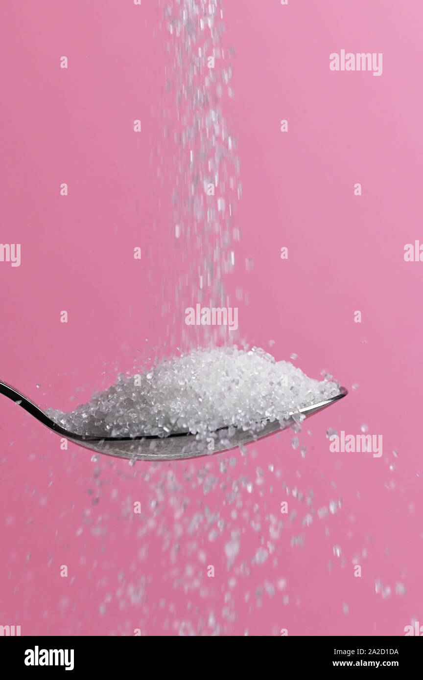 White Sugar Pouring From A Spoon Stock Photo
