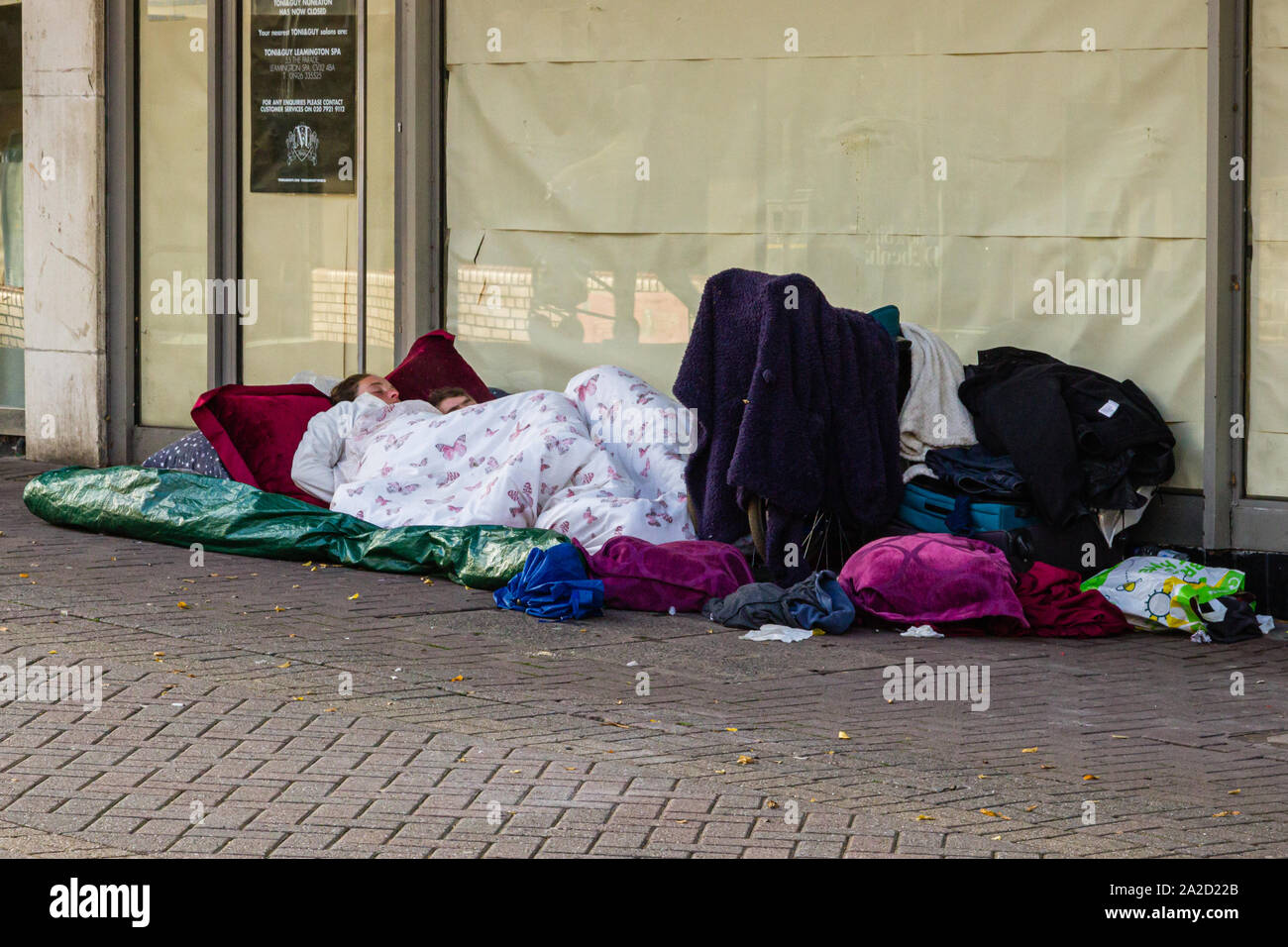 A homeless couple beded down outside an abandoned town centre shop sum up economic down turn Stock Photo
