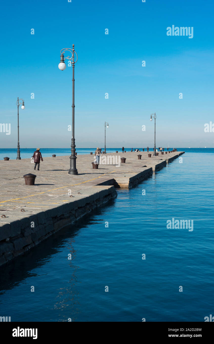 many people have walk at famous Audace Pier in Trieste city, Italy Stock Photo