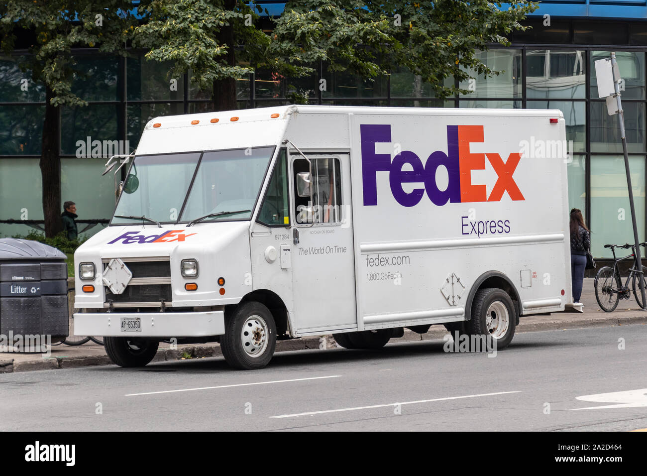 FedEx Express delivery van parked on the side of the road in a city. Stock Photo