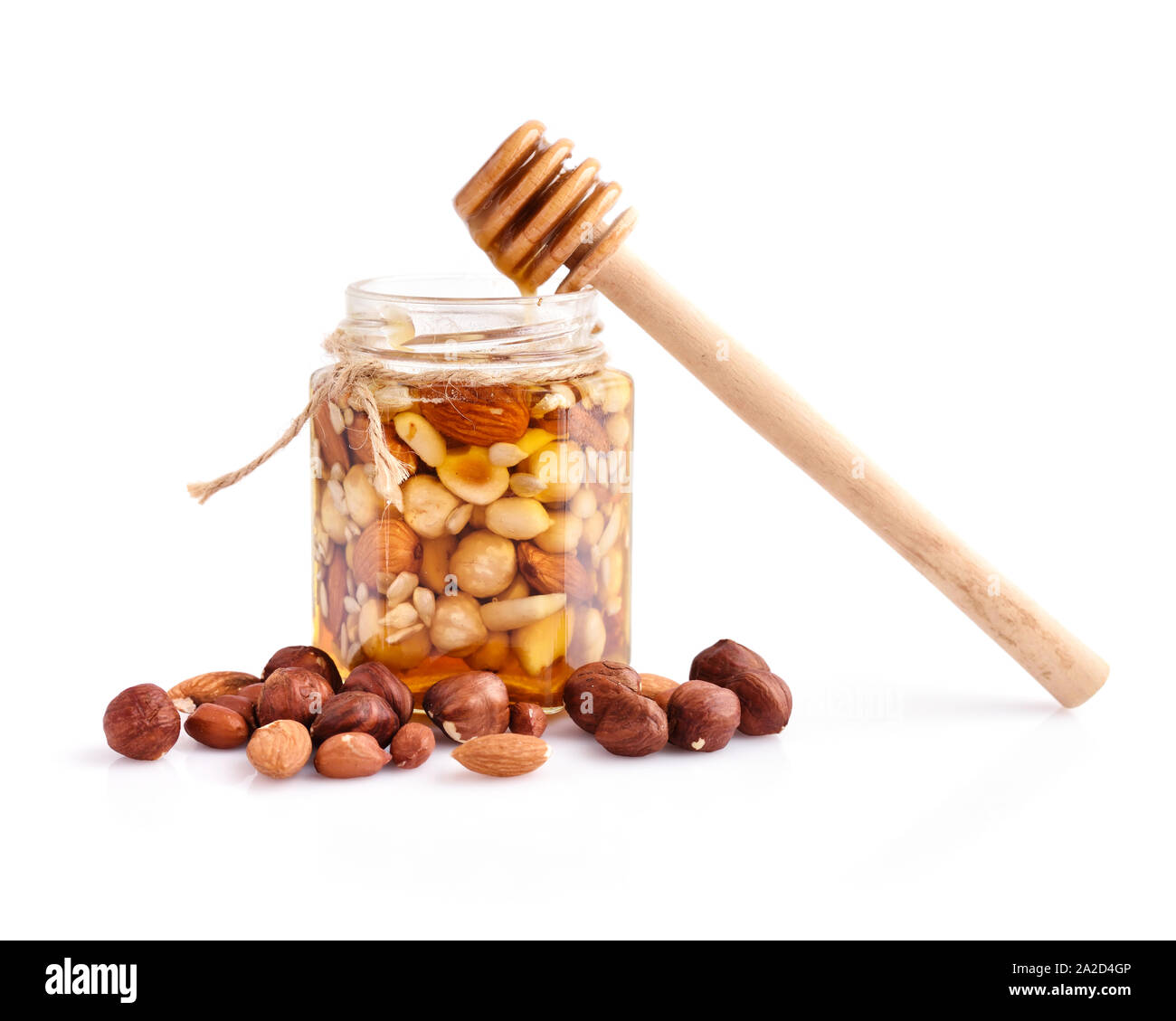 A honey jar with a spoon for honey and different nuts on white background  Stock Photo - Alamy