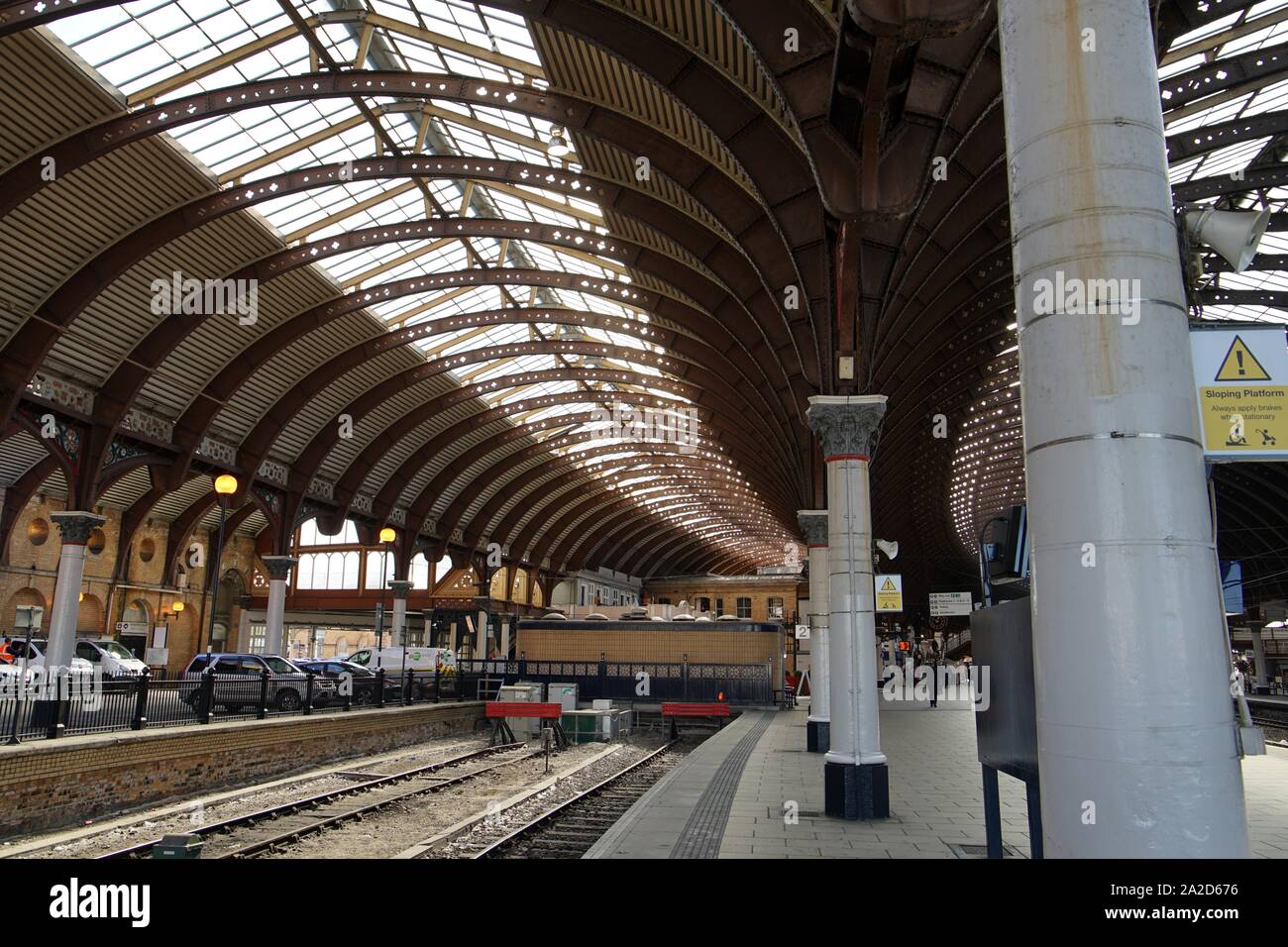 York railway station roof with wrought iron arches and cast iron support columns curving round the station platforms in York Yorkshire England Stock Photo