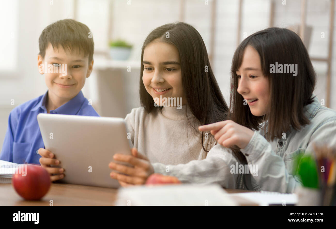 Pupils watching funny content on tablet in class Stock Photo