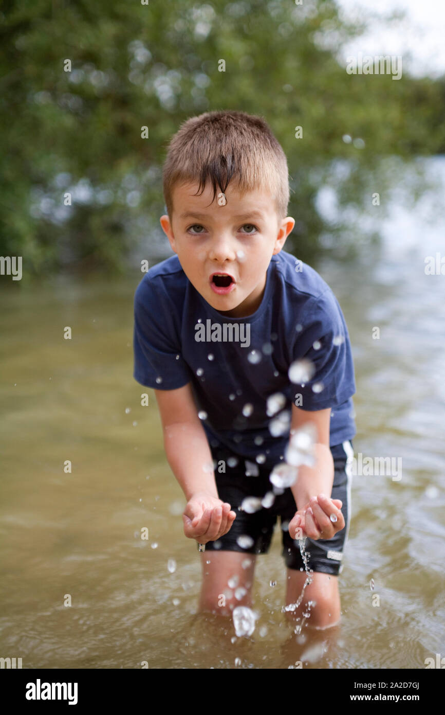Young boy playing in the river splashing and exploring Stock Photo - Alamy