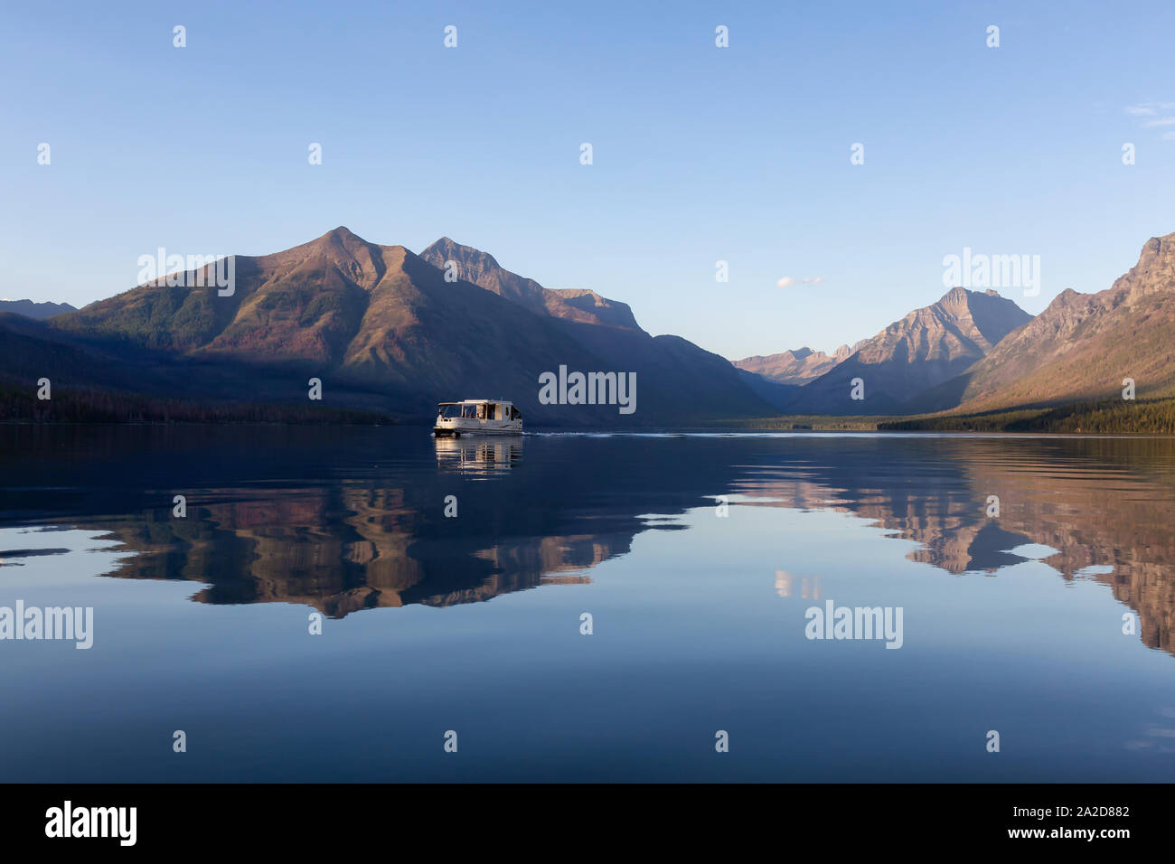 Glacier National Park, Montana, United States of America - September 1, 2019: Boat cruising in Lake McDonald with American Rocky Mountains in the back Stock Photo