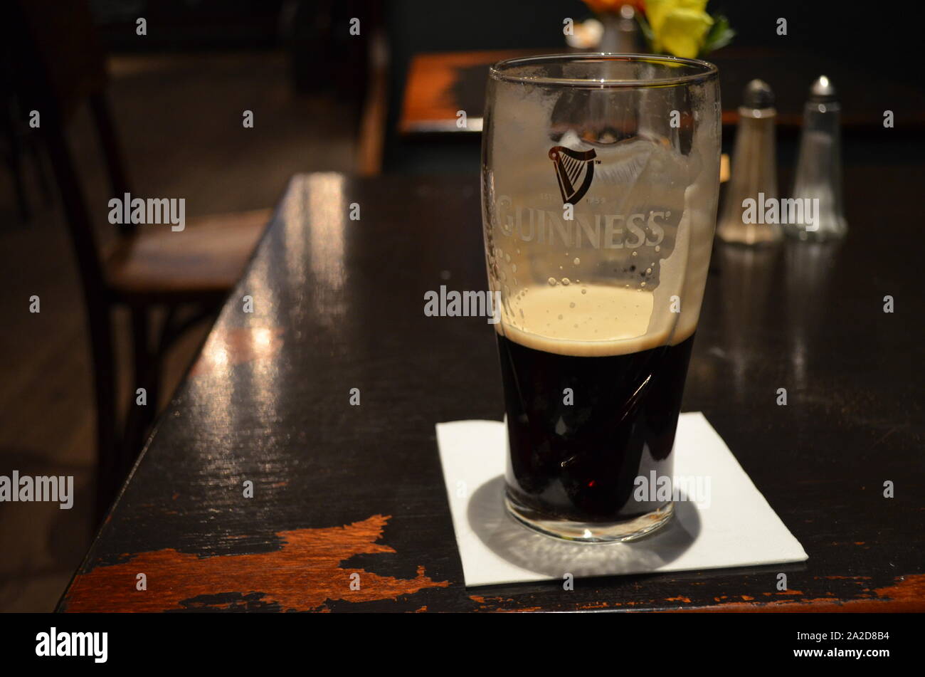 Almost empty pint of Guinness sitting on a pub table in Glasgow Stock Photo