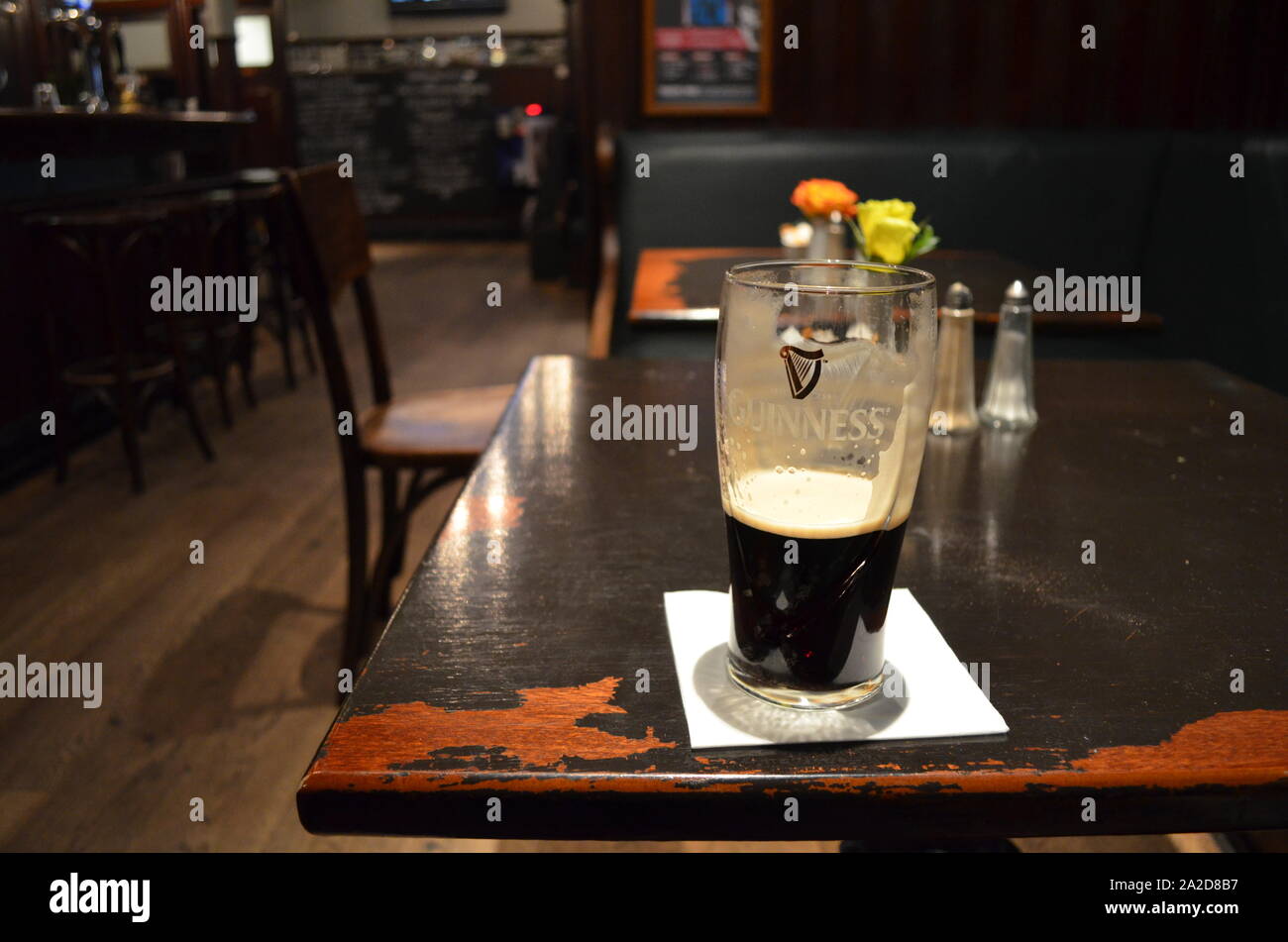 Almost empty pint of Guinness sitting on a pub table in Glasgow Stock Photo