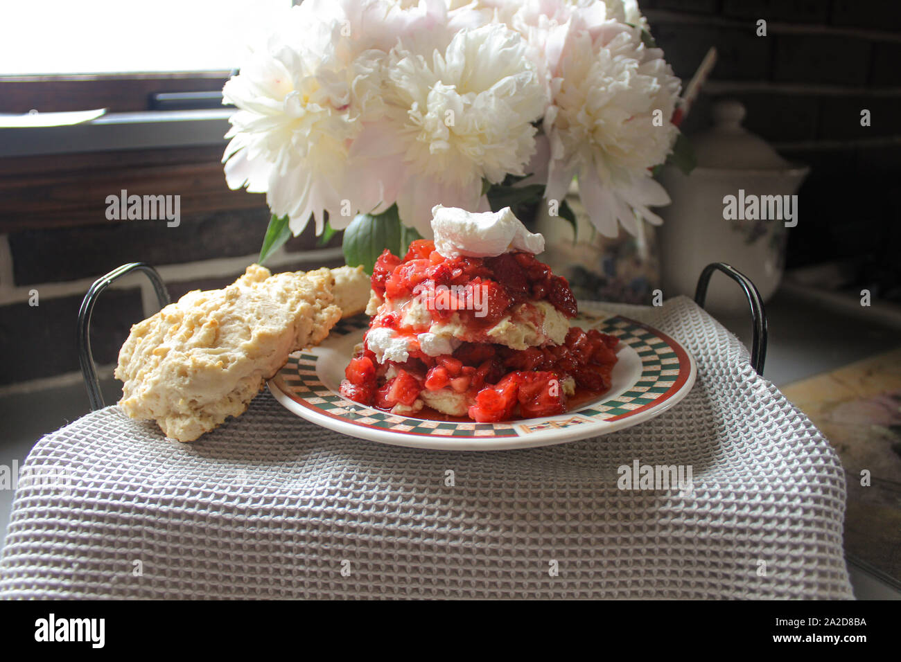 Prepared Strawberry Shortcake Dessert Stack In Front of Peonies Stock Photo