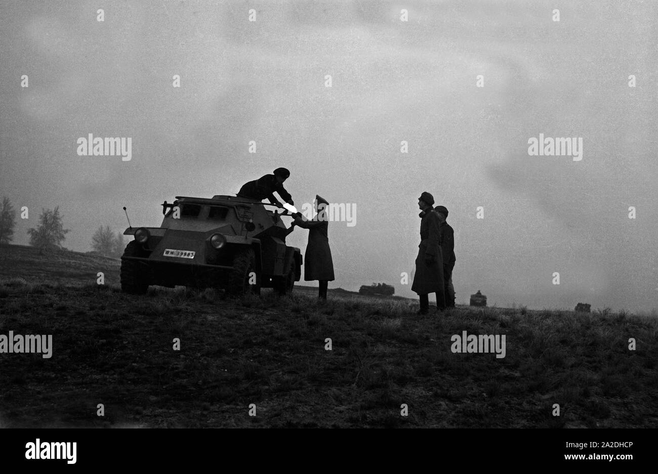 Offizier auf dem Truppenübungsplatz an einem Panzerspähwagen des Typs Sd.Kfz.221, Deutschland 1930er Jahre. An officer at a miltary training ground with an armoured scout car, Germany 1930s. Stock Photo