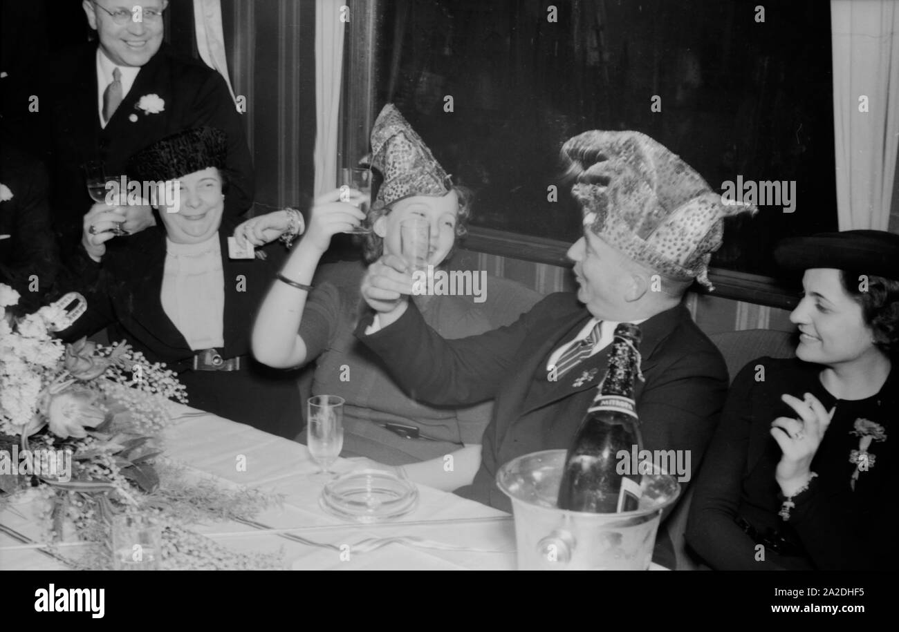 Die Prinzessin der Mainzer Fastnacht 1938, Hildegard Kühne, in fröhlicher Runde mit Seppel Glückert (?). Carnival princess Hildegard Kuehne raising her glass with Seppel Glueckert (?), 1938. Stock Photo
