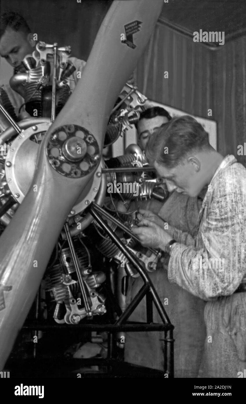 Mechaniker schrauben an einem Flugzeugmotor, Deutschland, 1930er Jahre. Mechanic screwing an airplane engine, Germany 1930s. Stock Photo