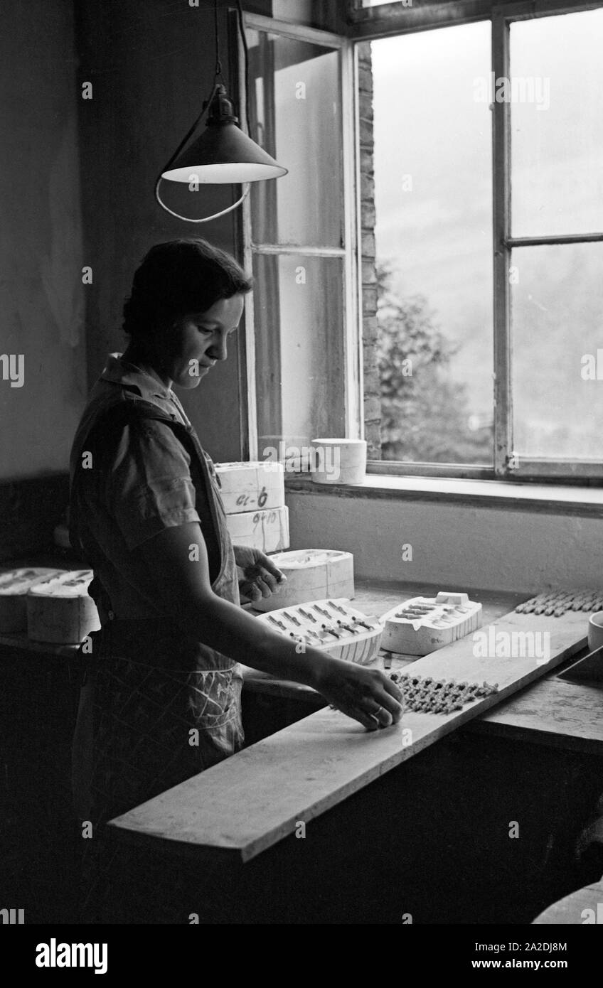 Eine Mitarbeiterin der Porzellanmanufaktur in Gräfenthal, Thüringen, gießt die Porzellanrohmasse in eine Gußform, Deutschland 1930s. A female worker of the porcellain factory at Graefenthal, Thuringia, pouring porcellain raw mixture into  a mold, Germany 1930s. Stock Photo