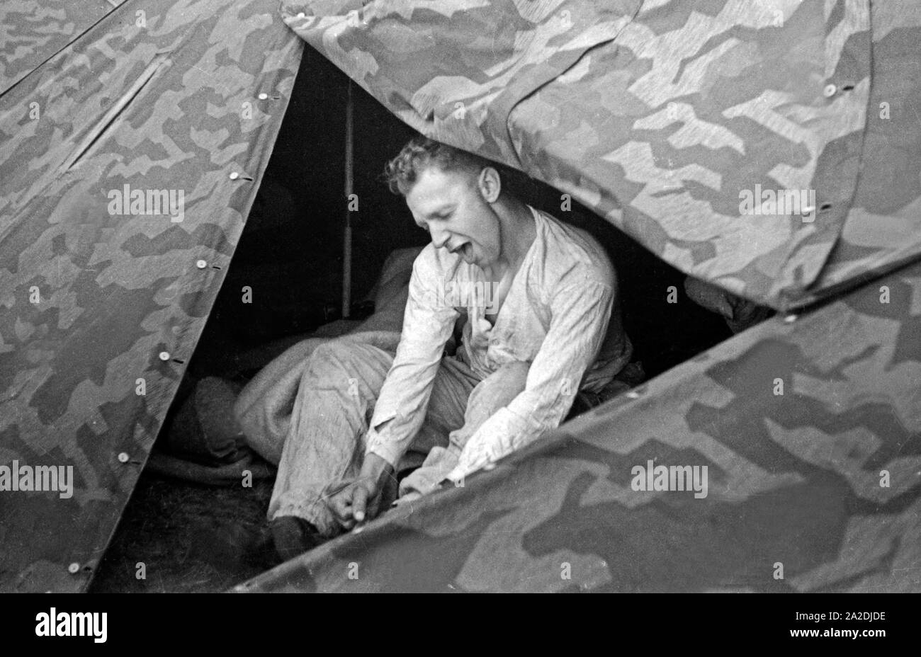 Rekrut der Flieger Ausbildungsstelle Schönwalde bereitet sich auf die Nachtruhe im Zelt vor, Deutschland 1930er Jahre. Recruit preparing to sleep in the tent, Germany 1930s. Stock Photo