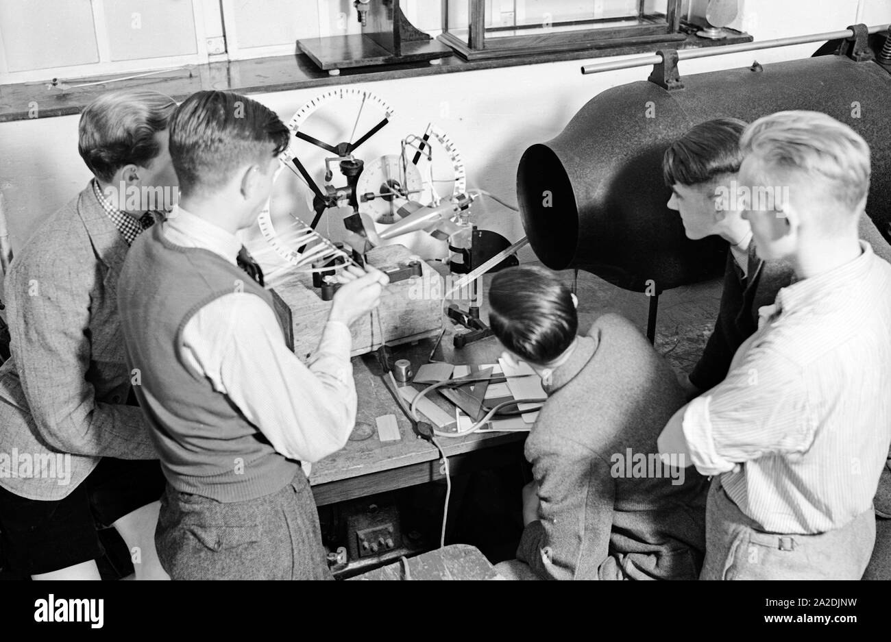 Flugschüler schauen sich anhand eines Modells die Steuerung eines Flugzeuges an, Deutschland 1930er Jahre. Pilot trainees studying the steering of a plane by observing a model, Germany 1930s. Stock Photo