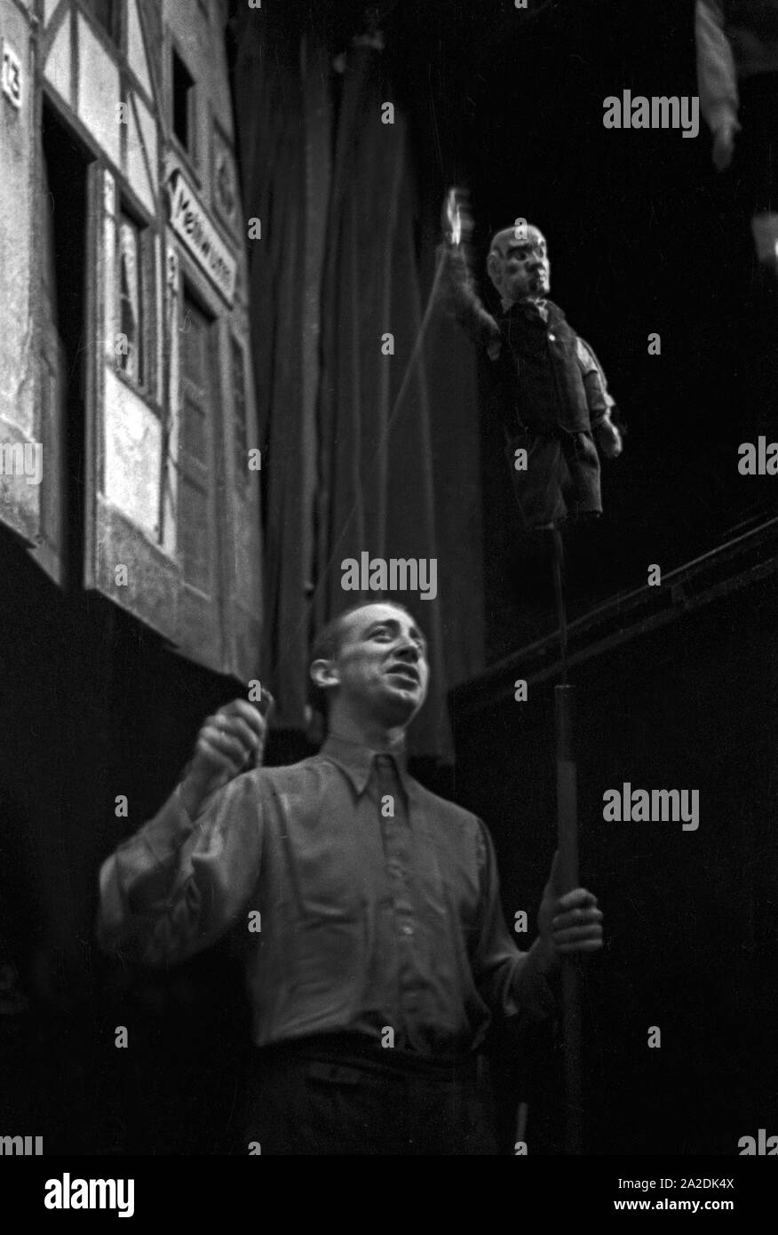 Ein Spieler des Kölsch Hänneschen Theaters in Köln mit seiner Puppe, Deutschland 1930er Jahre. A pupetteer with his puppet at the stickpuppet theatre at Cologne, Germany 1930s. Stock Photo