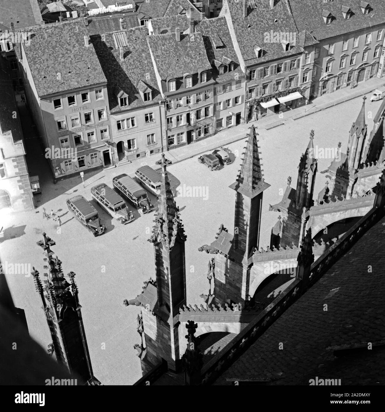Blick vom Turm des Münsters in Freiburg auf die Stadt und Reisebusse, Deutschland 1930er Jahre, View from the belfry of the minster at Freiburg to the roofs of the city and coaches, Germany 1930s. Stock Photo