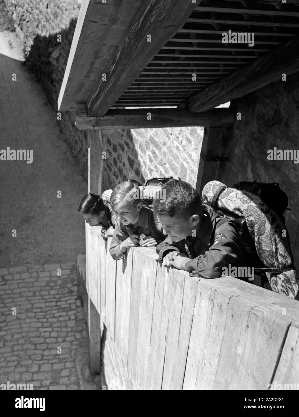 Drei Hitlerjungen kommen auf einer Wandertour durch Deutschland, 1930er Jahre. Three Hitler youths wandering through Germany, 1930s. Stock Photo