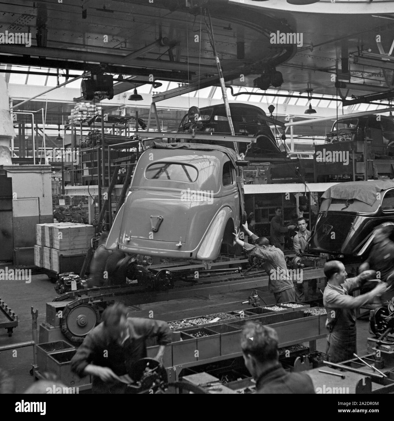 Arbeiter der Ford Werke in Köln Niehl am Fließband mit Karosserien, Deutschland 1930er Jahre. Workers at the conveyor belt of the Ford factory at Cologne, Germany 1930s. Stock Photo