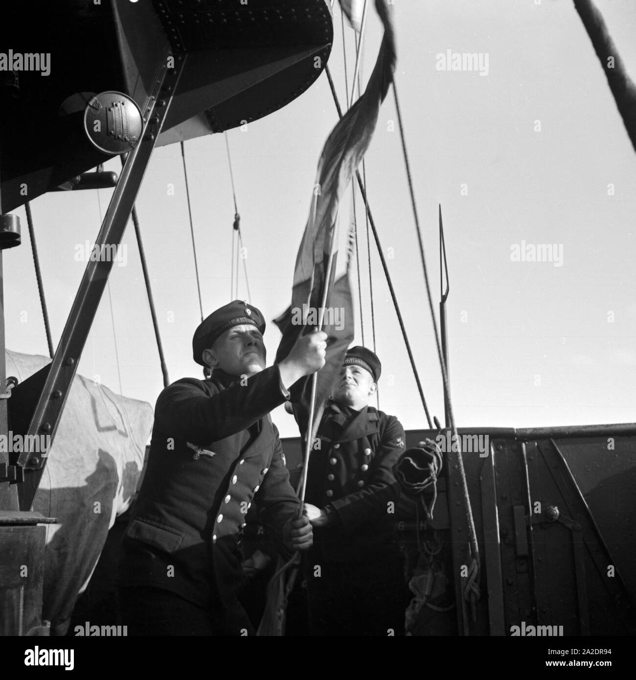 Marinerekruten der 2. Minensuchflottille beim Hissen der Flagge, Deutschland 1930er Jahre. Navy recruits of the 2nd minesweeper flotilla raising the flag, Germany 1930s. Stock Photo