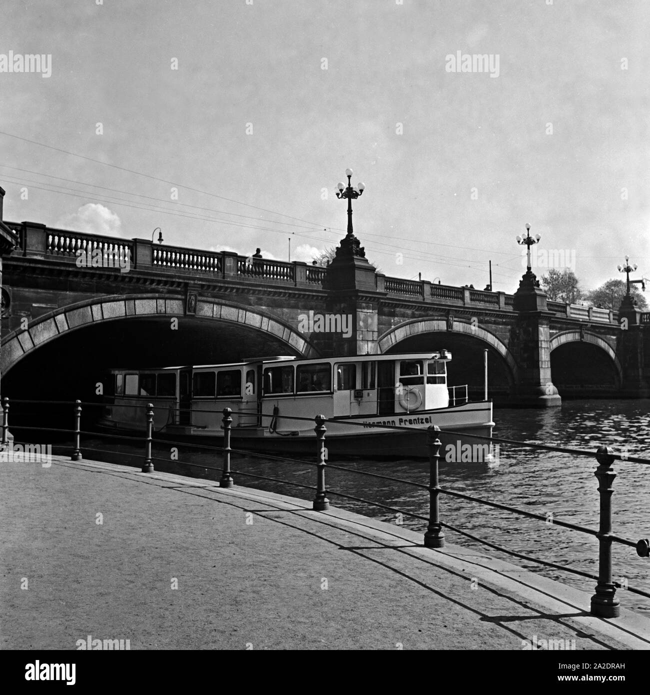 Eine Barkasse auf der Alster unter der Lombardsbrücke in Hamburg, Deutschland 1930er Jahre. A barge on the Alster under the Lombard bridge at Hamburg, Germany 1930s. Stock Photo
