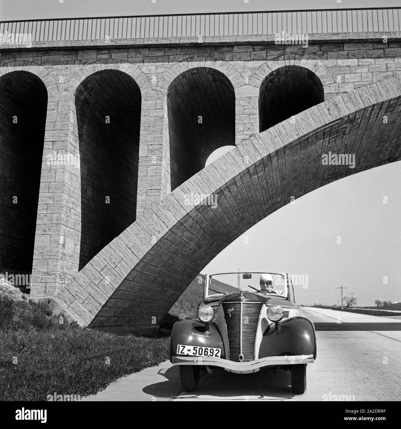 Mit dem Ford Eifel auf unter einer Brücke auf der Reichsautobahn, Deutschland 1930er Jahre. A Ford model Eifel under a bridge at the Reichsautobahn highway, Germany 1930s. Stock Photo