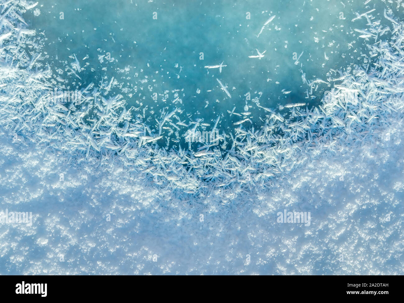 Winter background: close-up of frozen ice with snow crystals and
