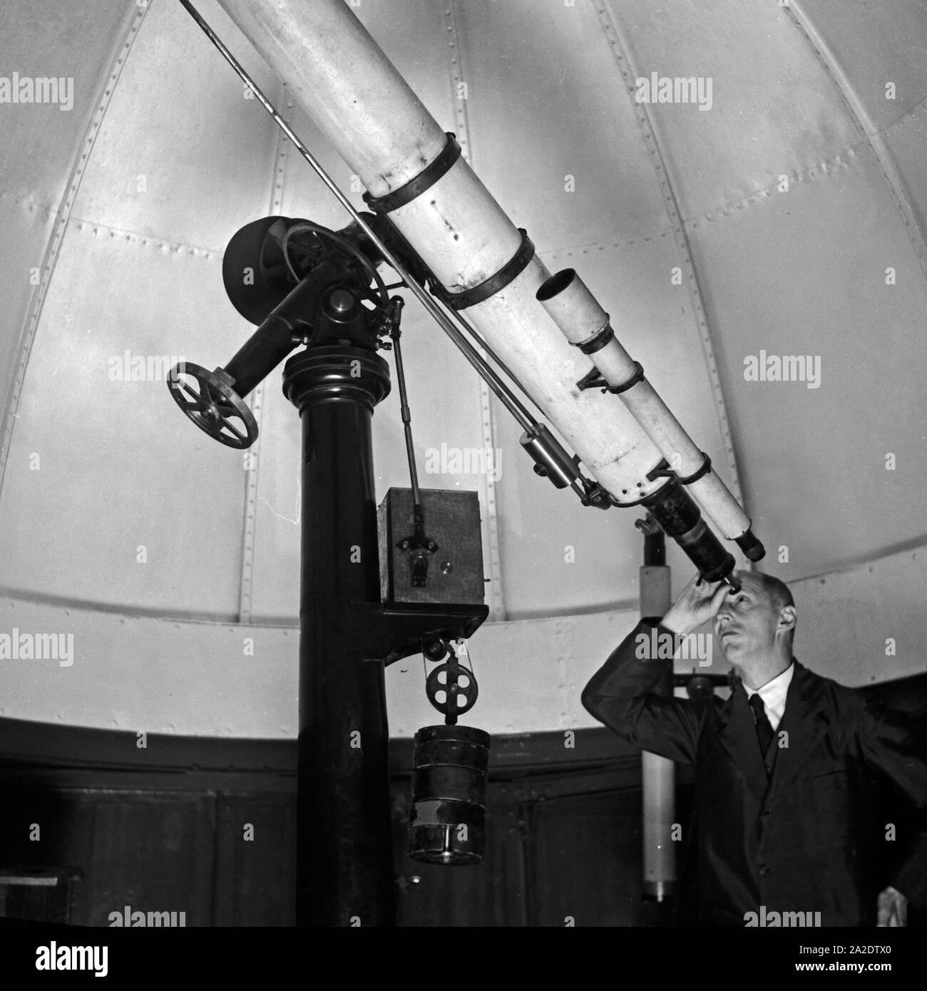 Ein Mitarbeiter erläutert am Teleskop in der Kuppel der Sternwarte Berlin  Treptow, Deutschland 1930er Jahre. A staff member at the telescope in the  dome of the Berlin Treptow observatory, Germany 1930s Stock