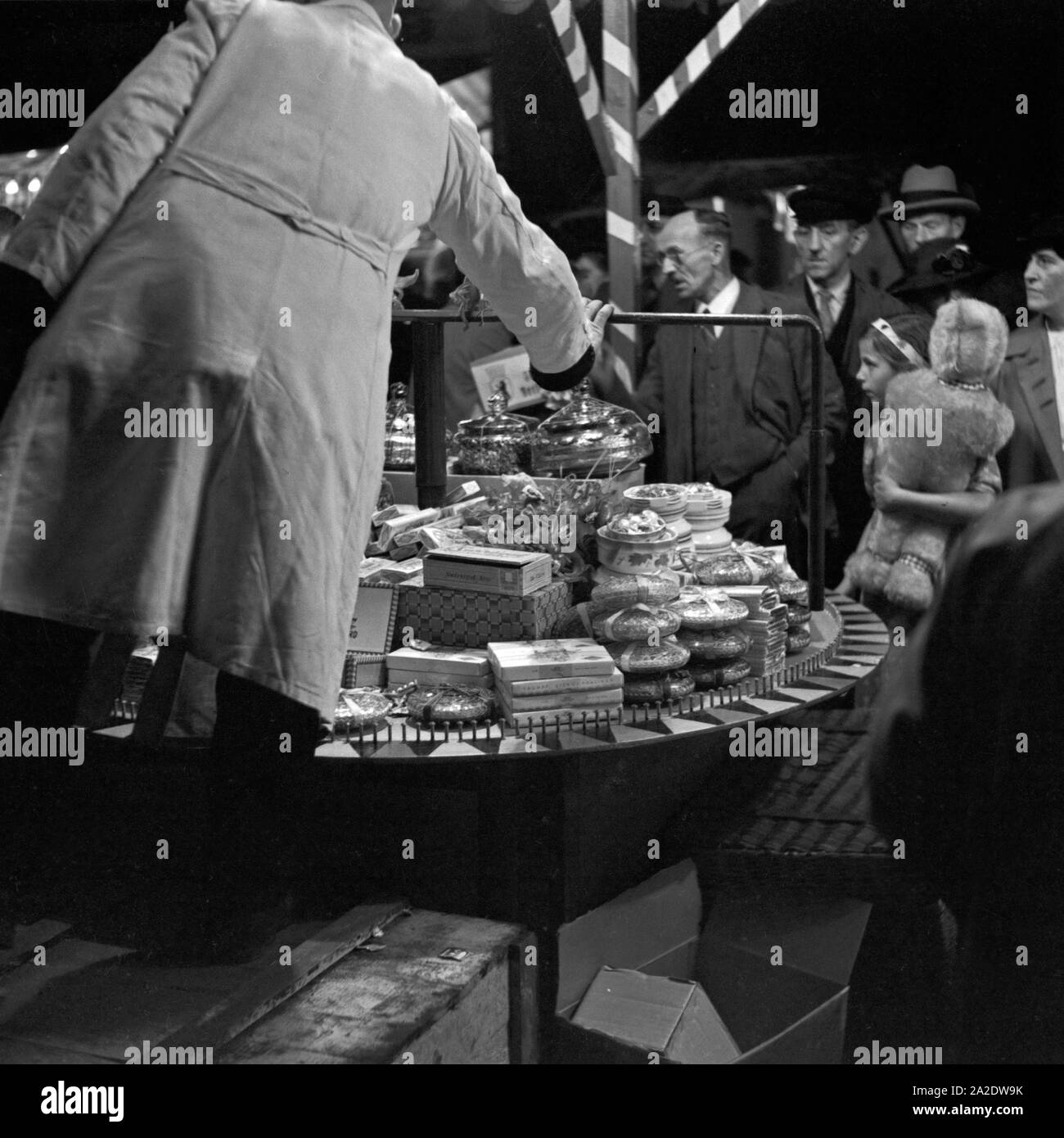 Beim Ringewerfen kann das Publikum viele Preise gewinnen auf der Festwiese in Berlin Stralau, Deutschland 1930er Jahre. Lots of prizes to be won at the skillgaming booth at the Berlin Stralau annual fair, Germany 1930s. Stock Photo
