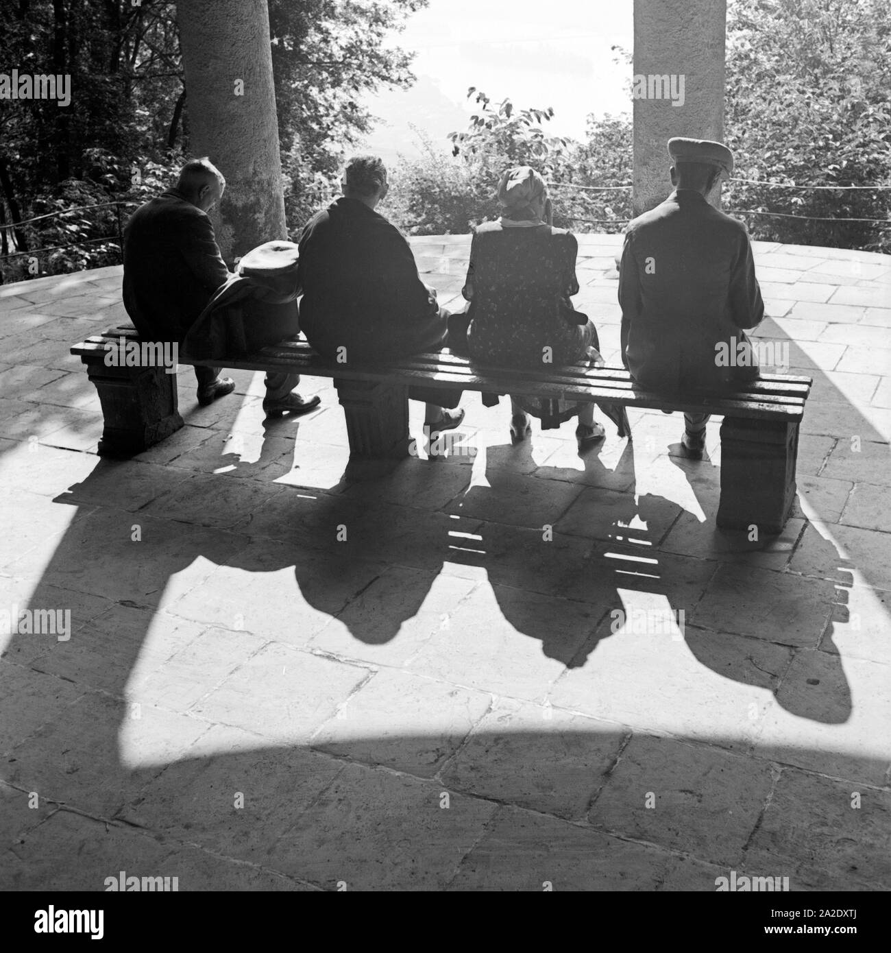 Vier Personen sitzen in der Sonne auf einem Aussichtspunkt, Deutschland 1930er Jahre. Four persons sitting in the sun at a viewpoint, Germany 1930s. Stock Photo