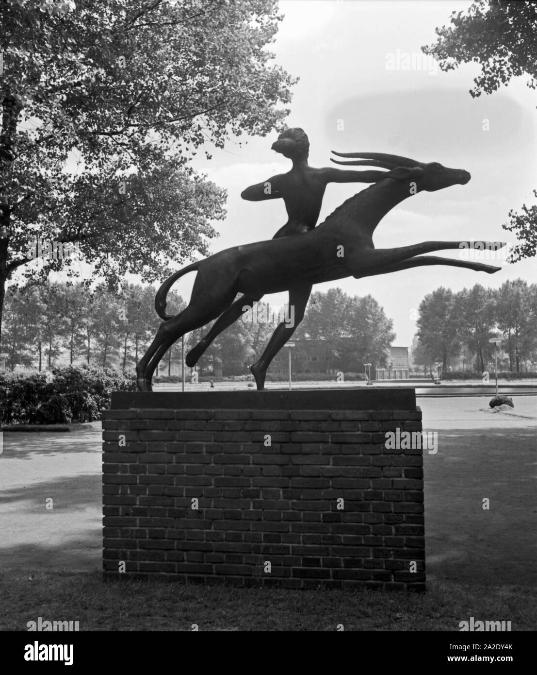 Eine Statue im Rheinpark in Köln zeigt Gottin Diana und einen Hirschen, 1930er Jahre. A statue at the Cologne Rheinpark shows goddess Diana with a deer, 1930s. Stock Photo