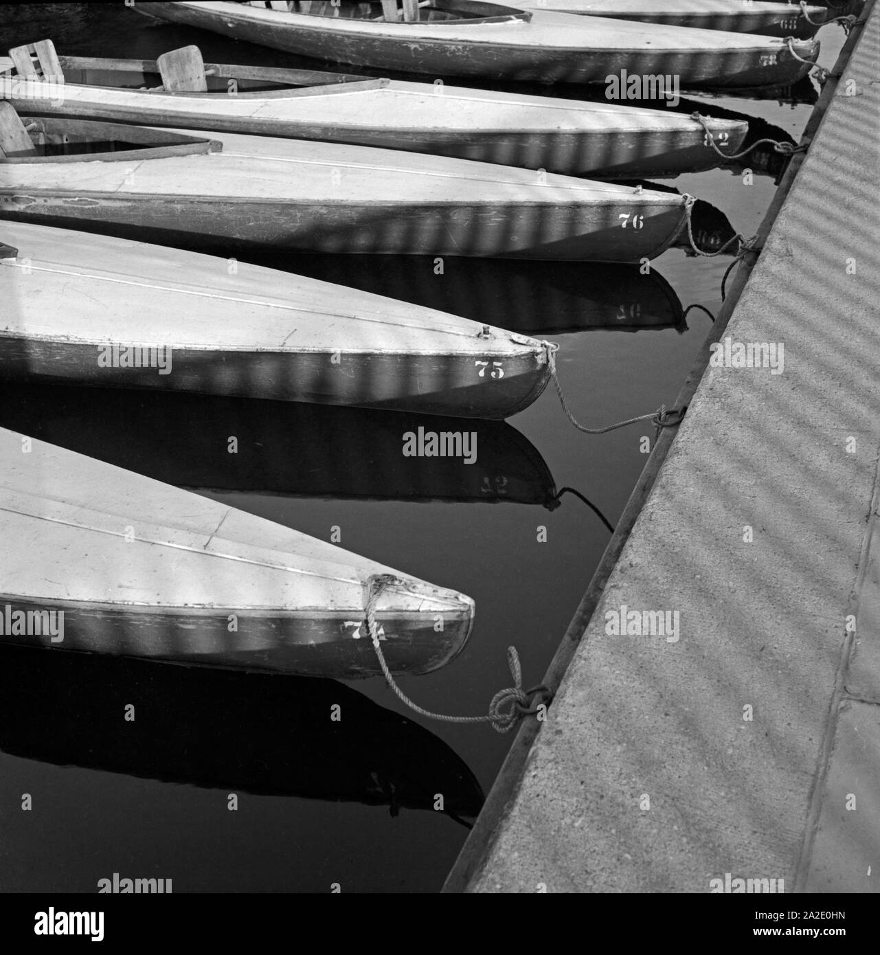 Paddelboote warten am Verleihsteg am Maschsee auf ihre nächsten Paddler, Hannover Deutschland, 1930er Jahre. Canoes at the boat rental waiting for their next usage at Maschsee lake near Hanover, Germany 1930s. Stock Photo