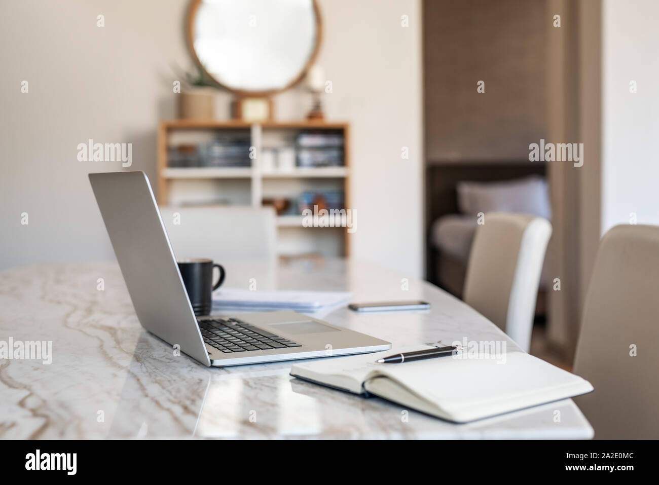 Laptop and notebook on a table in an apartment Stock Photo