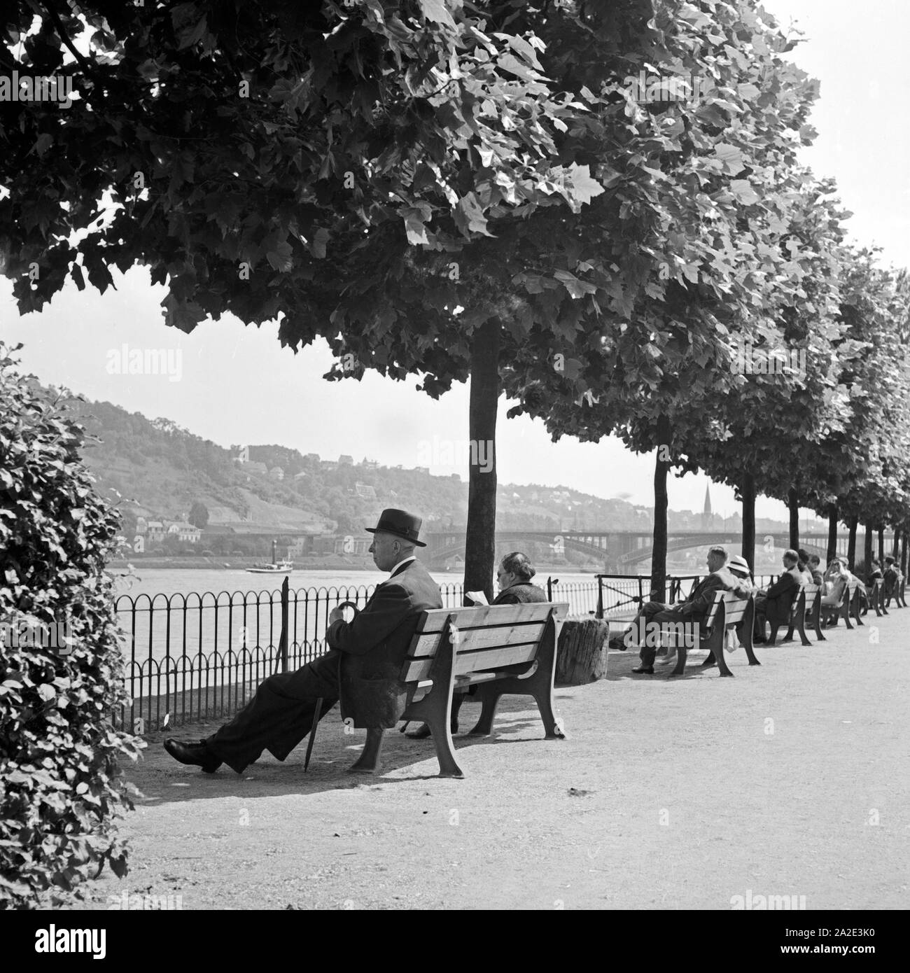 Menschen sitzen am Ufer des Rheins bei Koblenz, Deutschland 1930er Jahre. People sitting on the shore of river Rhine at Koblenz, Germany 1930s. Stock Photo