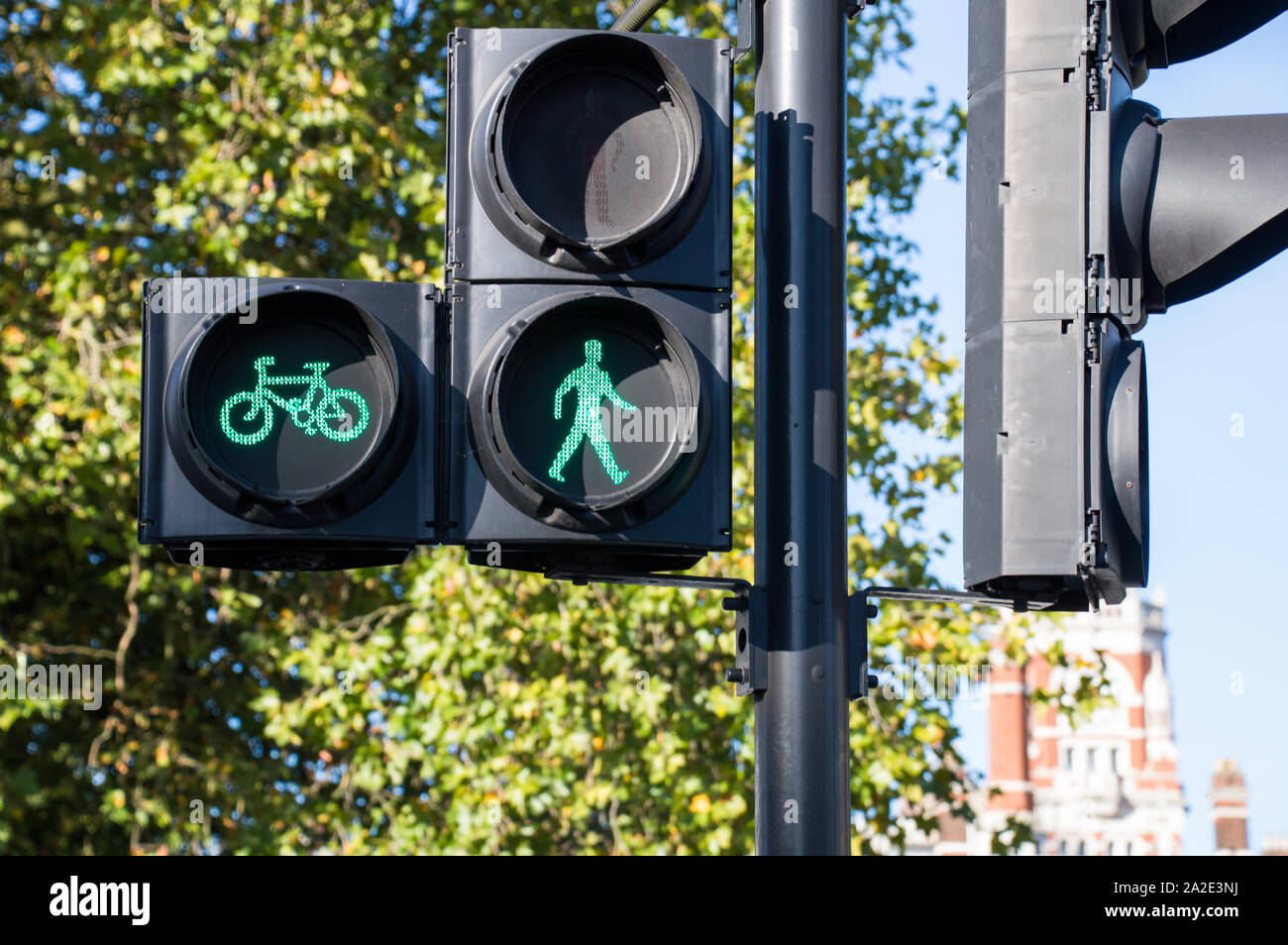Man and Cycle crossing point illuminated with green signal Stock Photo