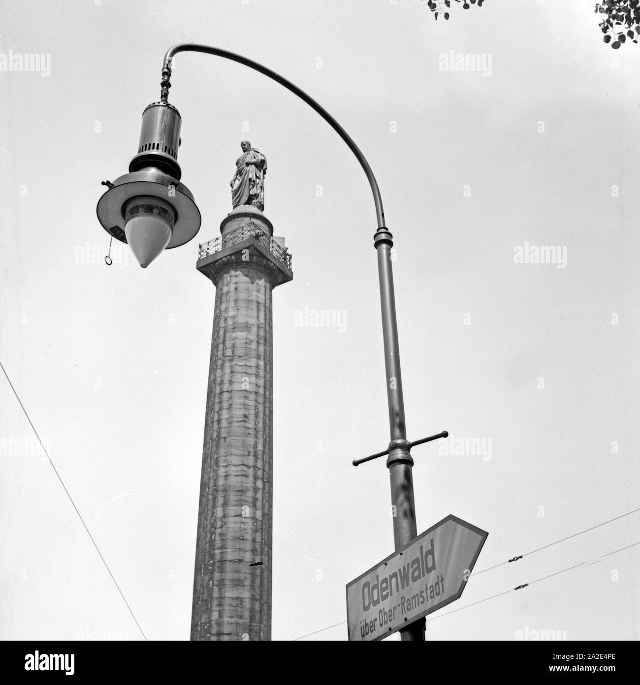 Die Ludwigssäule auf dem Luisenplatz in Darmstadt mit Straßenlaterne und einem Wegweiser in den Odenwald, Deutschland 1930er Jahre. Ludwig's column at Luisenplatz square at Darmstadt with street lantern and fingerpost to Odenwald forest, Germany 1930s. Stock Photo