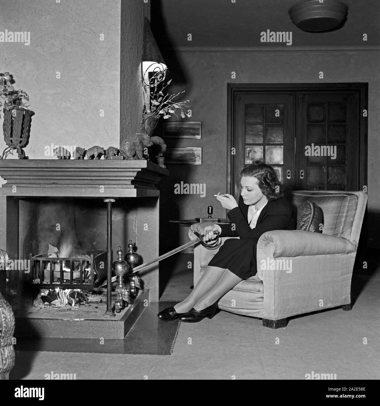 Die schwedische Schauspielerin und Sängerin Zarah Leander am Kamin in ihrem Haus in Berlin, Deutschland 1930er Jahre. Swedish singer and actress Zarah Leander at the fireplace in her house at Berlin, Germany 1930s. Stock Photo