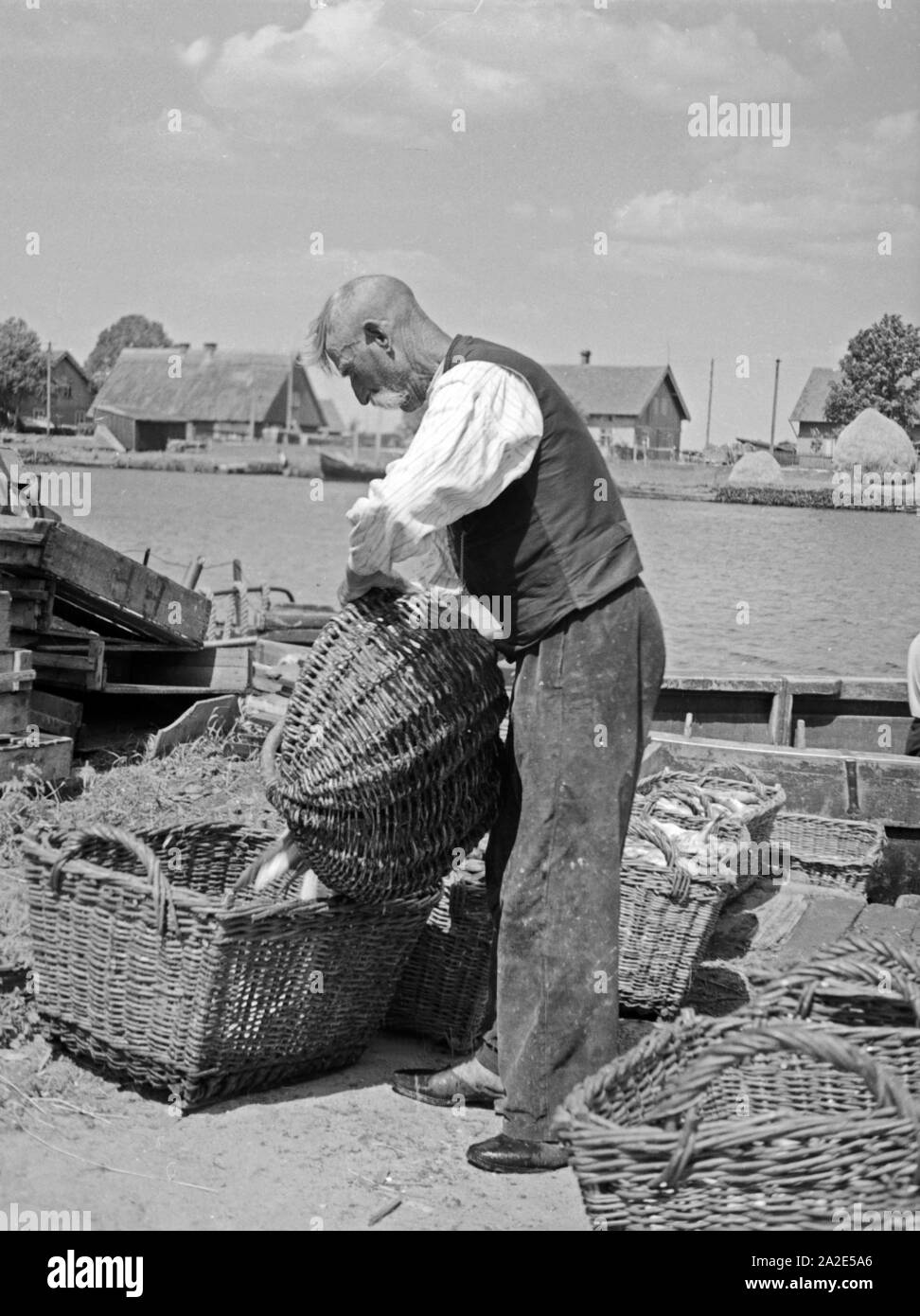 Ein Fischer ist sehr zufrieden mit seinem Fang in Karkeln im Memeldelta, Ostpreußen, 1930er Jahre. A fisherman, happy with his yield of fish at Karkeln in the Memel delta, East Prussia, 1930s. Stock Photo