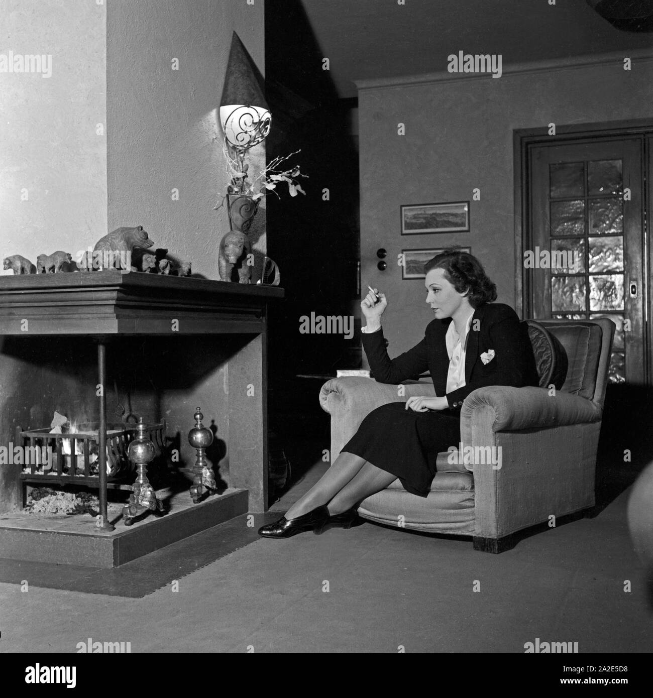 Die schwedische Schauspielerin und Sängerin Zarah Leander am Kamin in ihrem Haus in Berlin, Deutschland 1930er Jahre. Swedish singer and actress Zarah Leander at the fireplace in her house at Berlin, Germany 1930s. Stock Photo