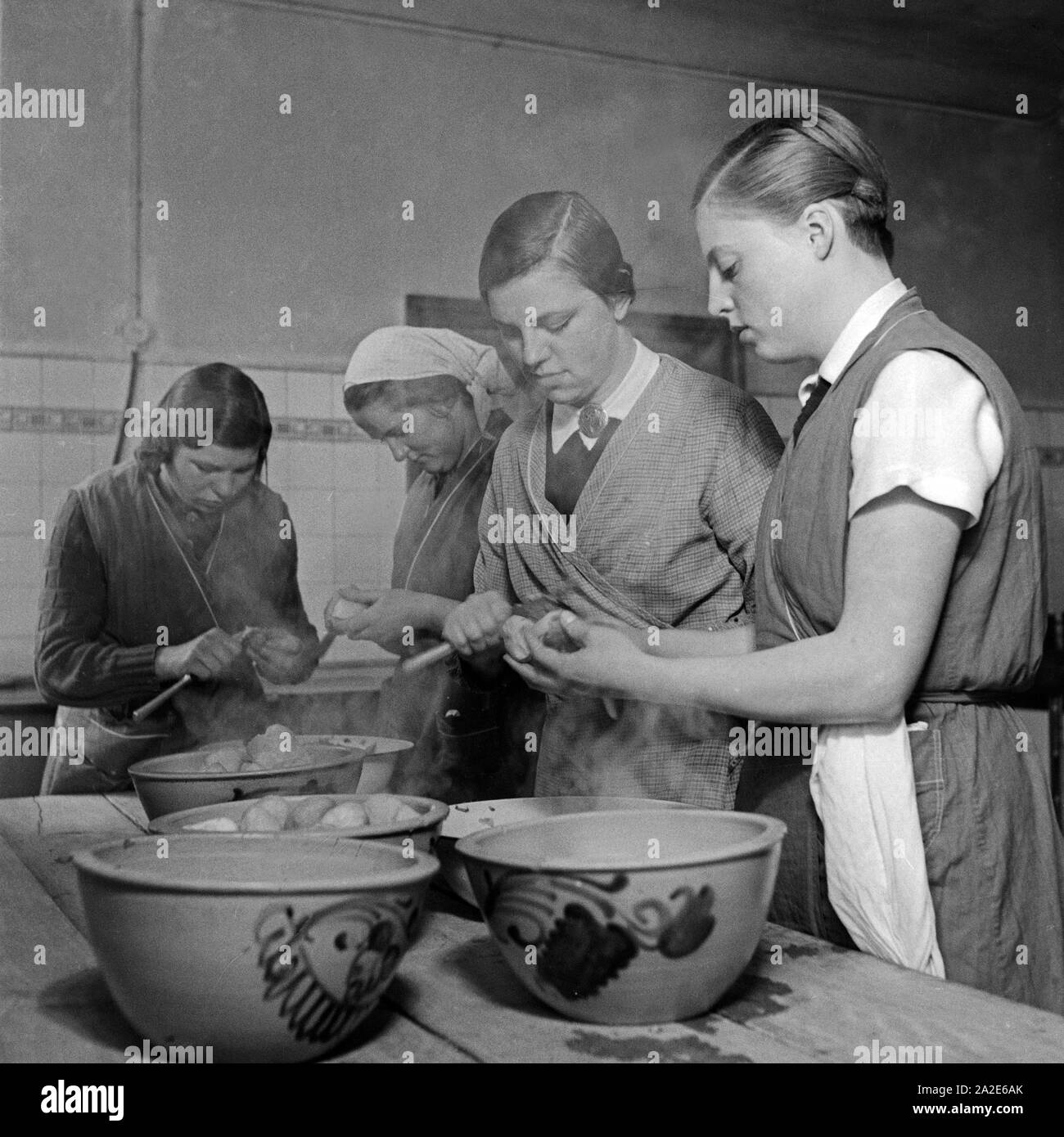 Frauen schälen Pellkartoffeln beim weiblichen Arbeitsdienst in Molkenberg bei Fürstenwalde, Deutschland 1930er Jahre. Women peeling potatoes in the skin at the female workforce group of Molkenberg, Germany 1930s. Stock Photo