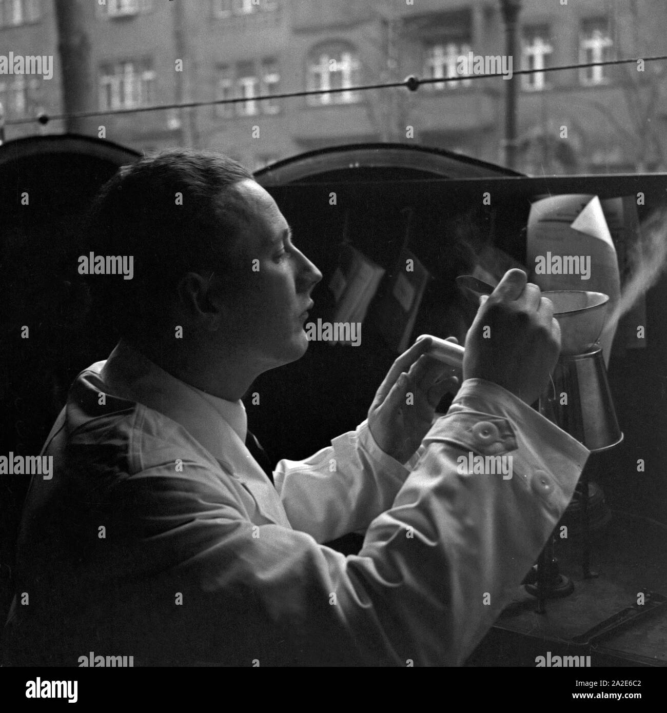 Ein Apothekerlehrling kocht ein Medikament zusammen, Deutschland 1930er Jahre. A pharmacy trainee mixing and producing medicine, Germany 1930s. Stock Photo